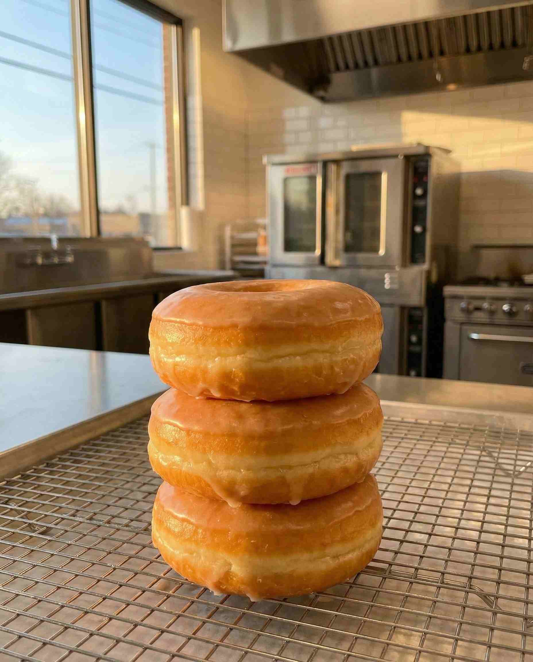 Stack of perfectly shaped glazed donuts with high volume, showcasing Polysorbate 60's ability to improve texture and reduce oil absorption in fried dough.